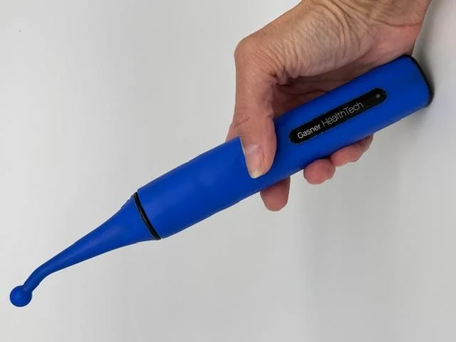 A hand holding the blue PhysioJaw device with the Gasner HealthTech wordmark on the handle